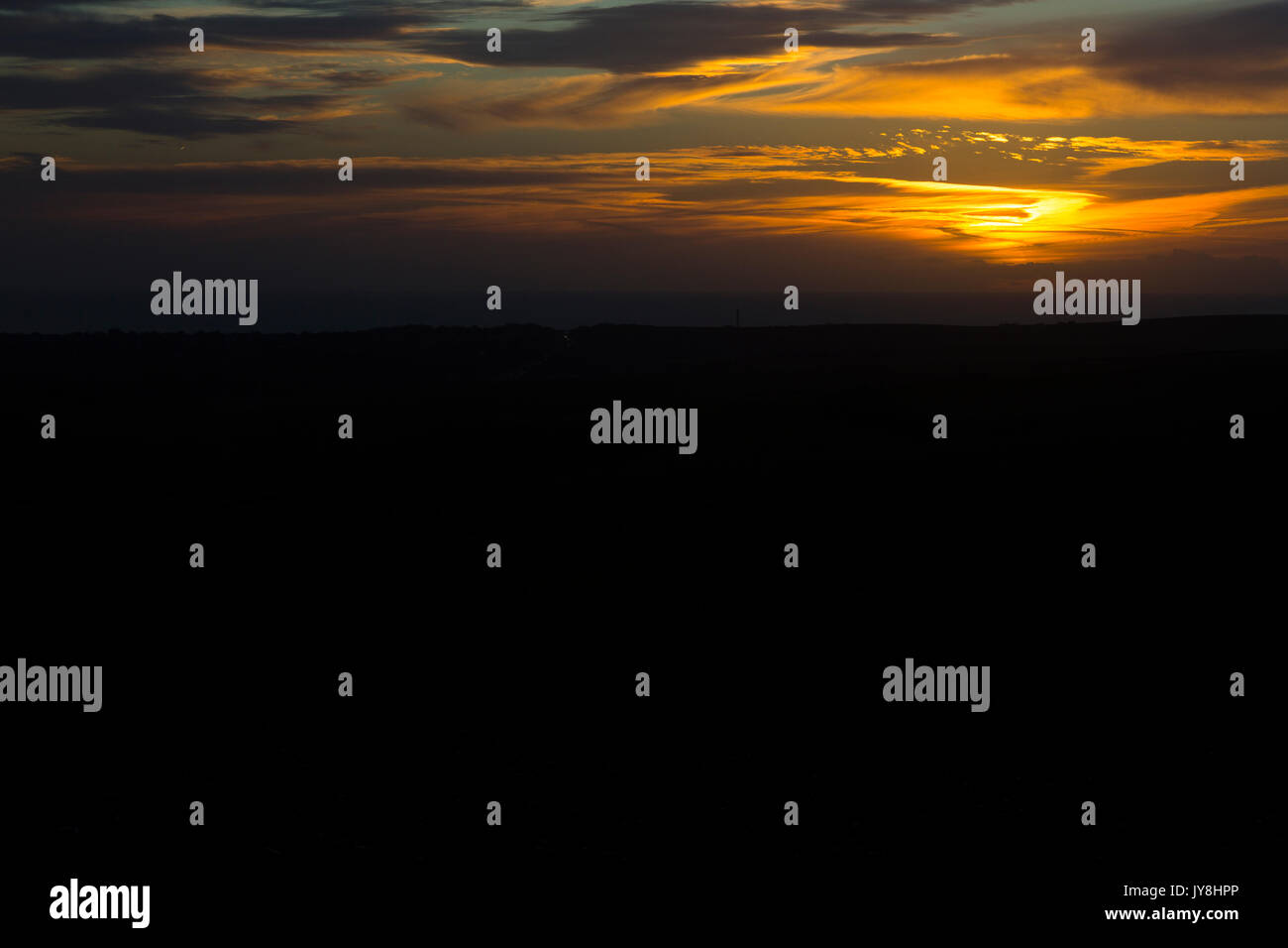 Ditchling Beacon, Sussex, UK. Orange profond un coucher de soleil sur la campagne du Sussex qui se profile. Banque D'Images