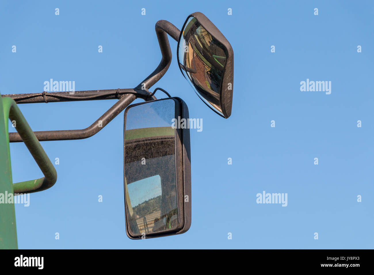 L'agriculture britannique, récolter les réflexions dans les miroirs d'une moissonneuse-batteuse contre un fond de ciel bleu clair Banque D'Images