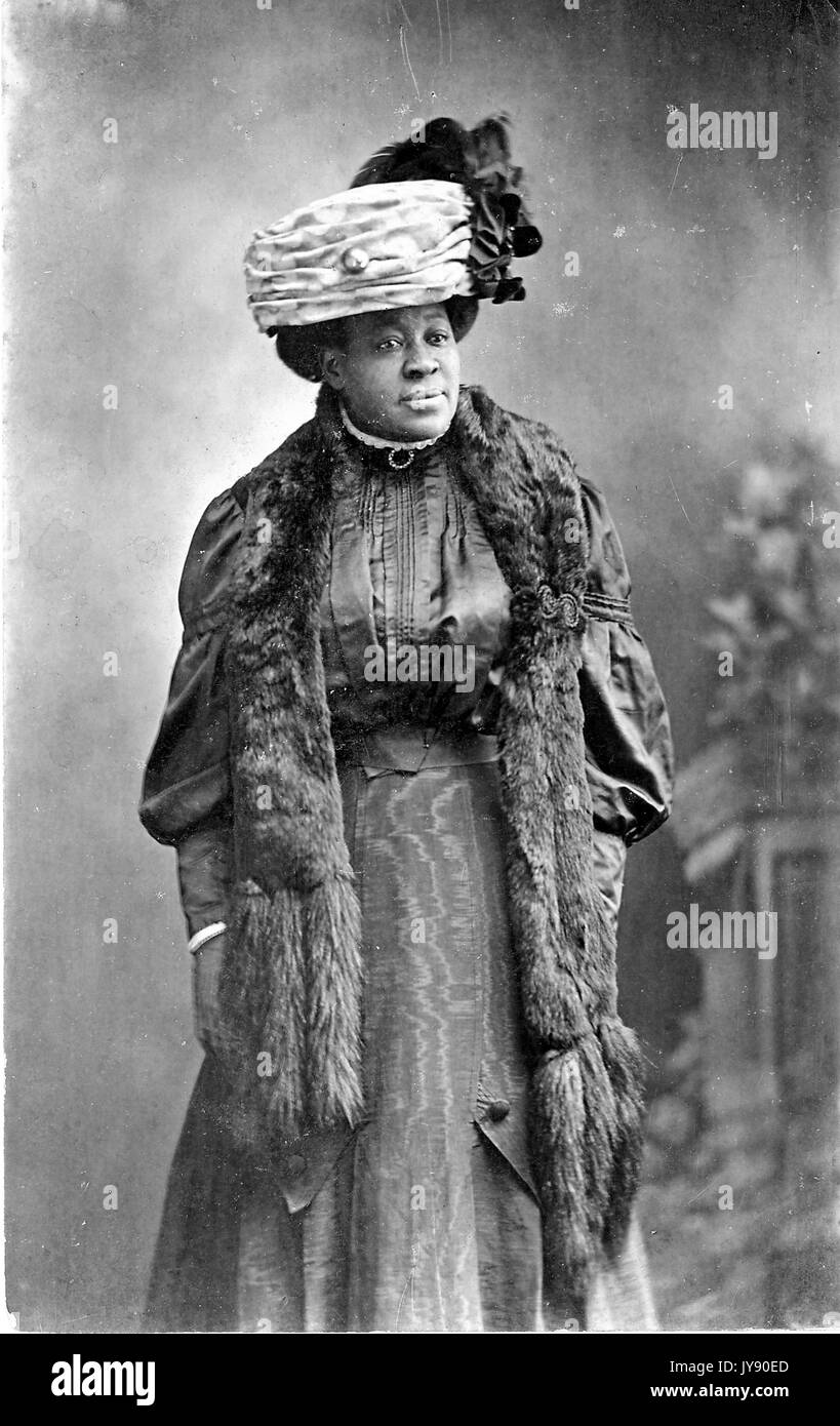 Portrait d'un african american woman standing, portant un chapeau et étole de fourrure, 1915. Banque D'Images