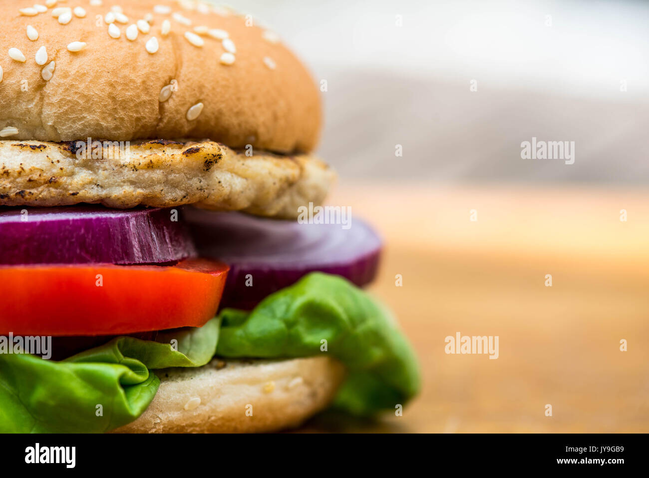 Burger de poulet ou dans un sandwich de pain de sésame avec salade fraîche Banque D'Images