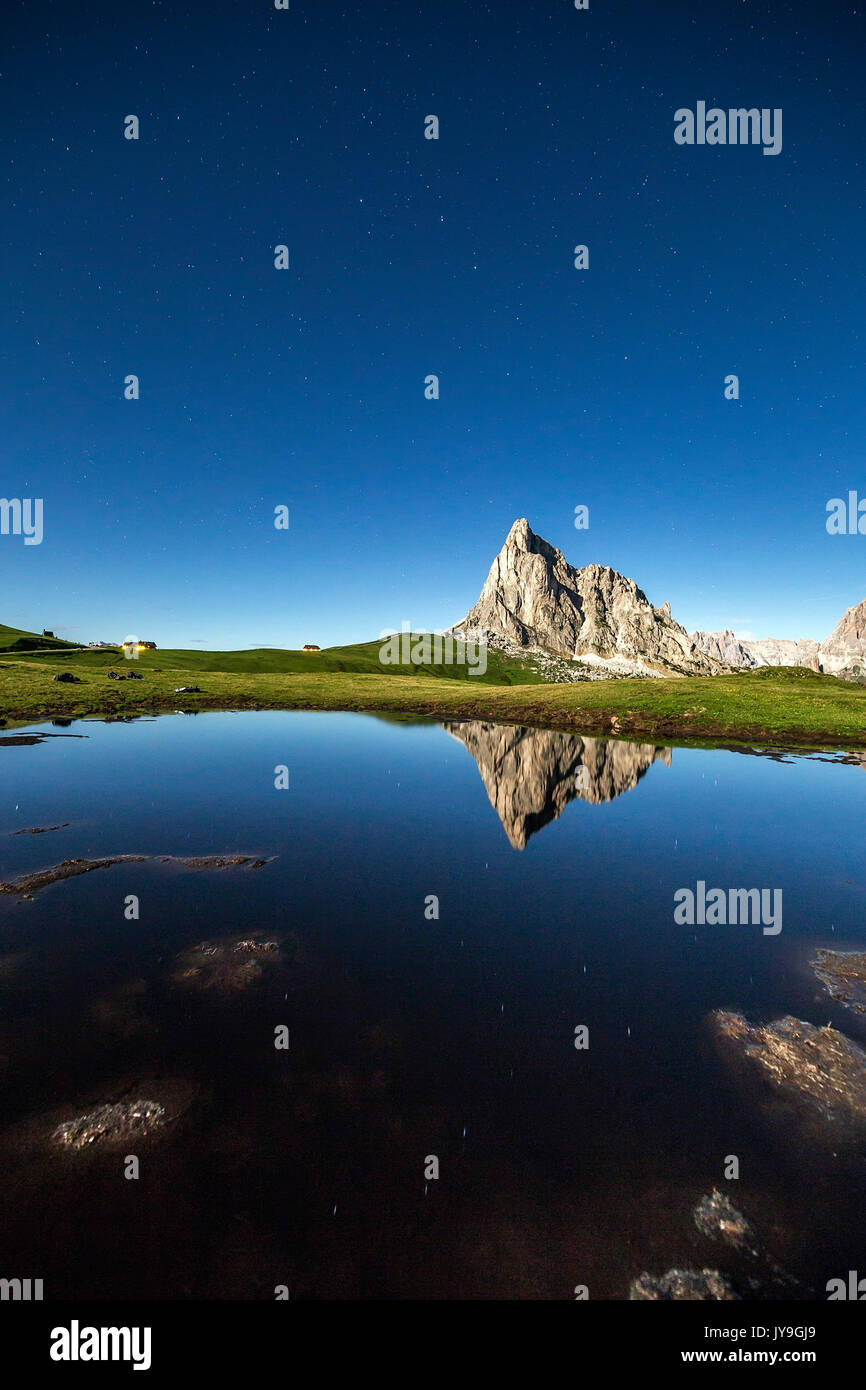 Le profil de la gusela se reflète dans une flaque à giau pass durant une nuit de pleine lune. Cortina d'ampezzo. dolomites. veneto italie. L'Europe. Banque D'Images