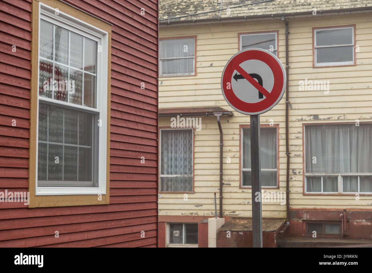 Pas de virage à gauche rue bâtiment jaune et rouge recto verso recto verso sur un coin de rue à St Pierre et Miquelon. Banque D'Images