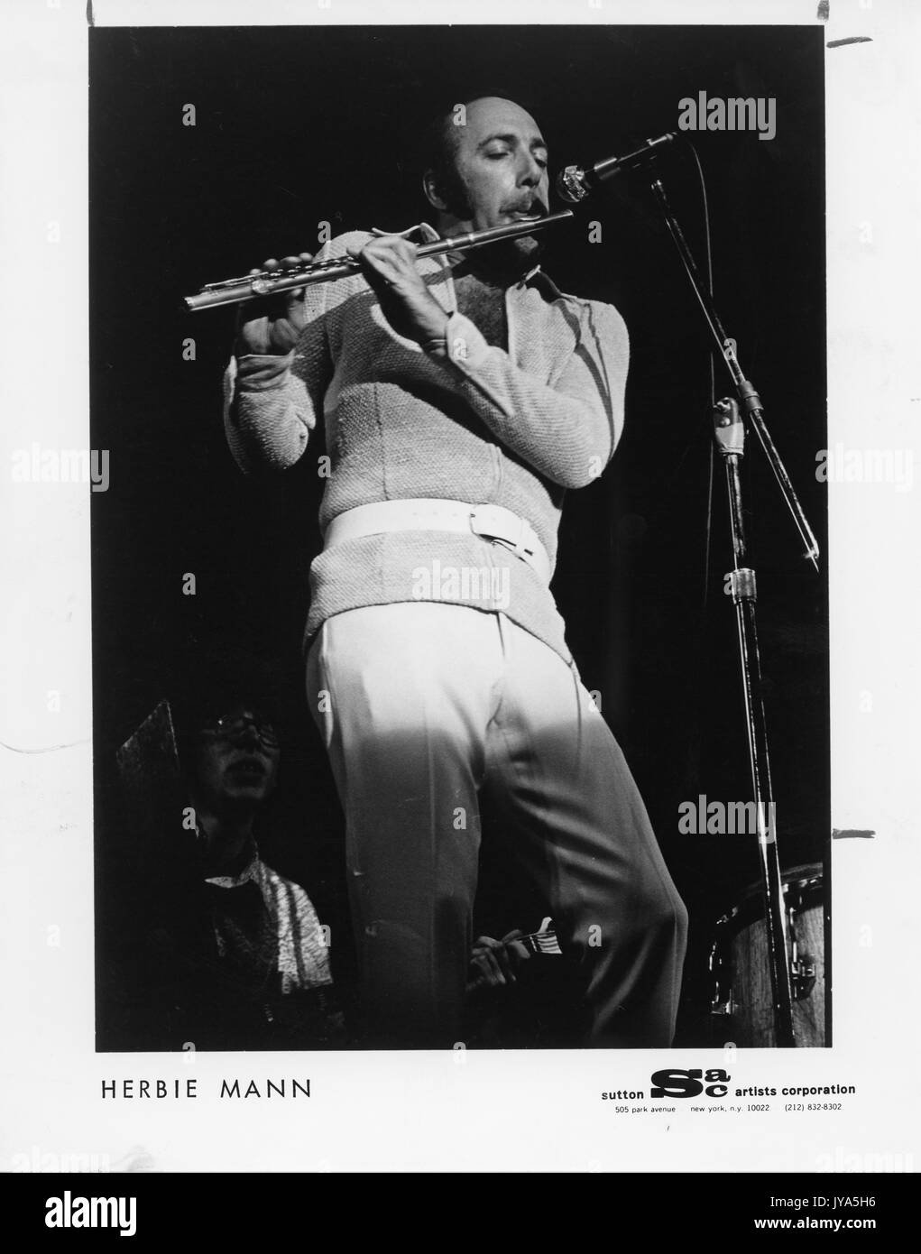 Photographie d'Herbie mann, célèbre flûtiste de jazz américain, debout sur scène sous les projecteurs tout en jouant de la flûte devant un microphone, 1970. Banque D'Images