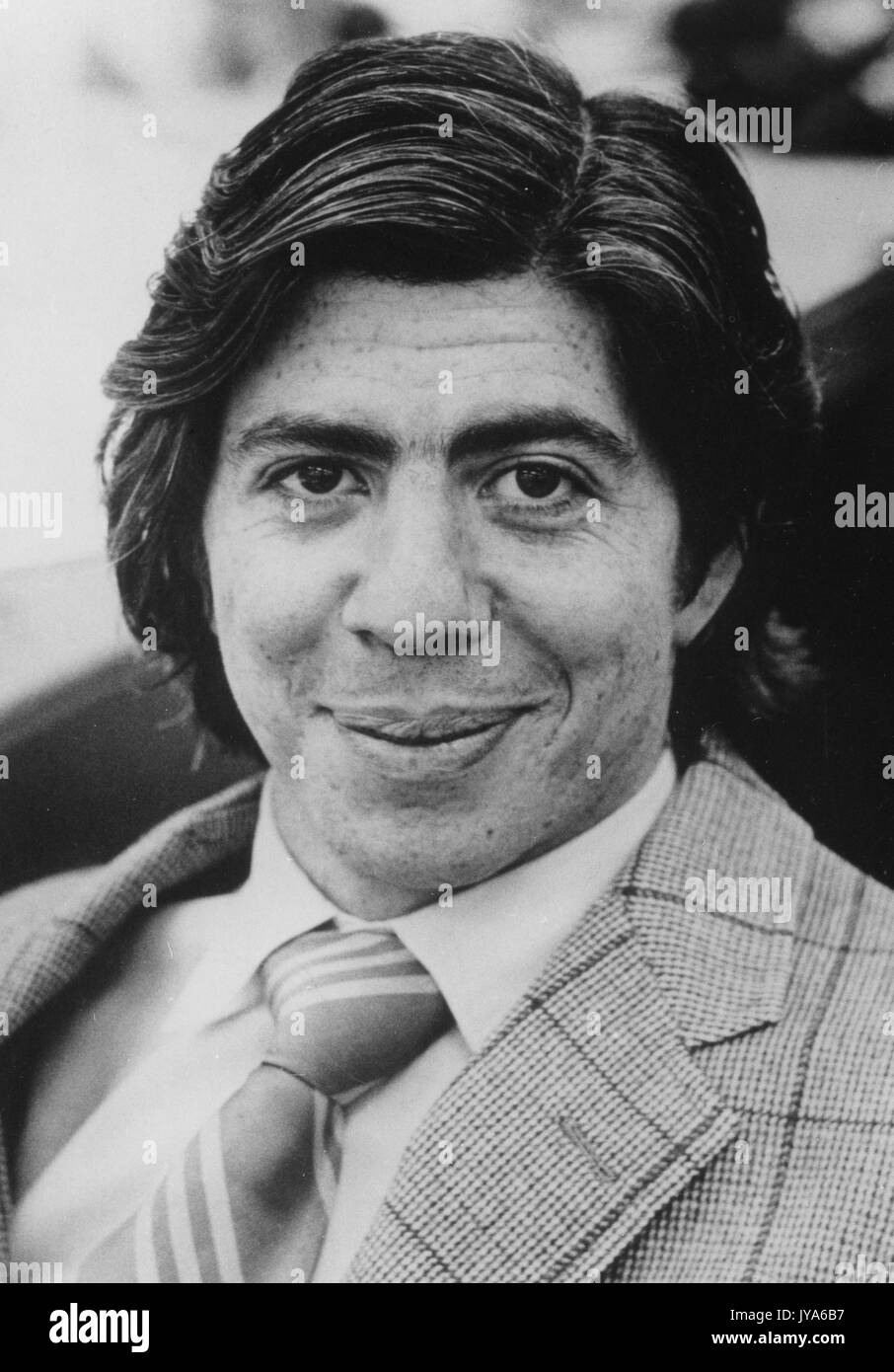 Tête de Carl Bernstein, portant un costume à motifs et une cravate rayée avec une chemise blanche, avec une expression faciale souriante. 1975. Banque D'Images