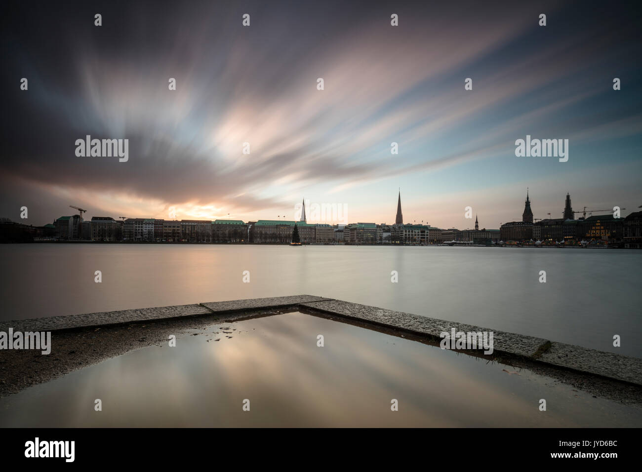 Les nuages et les lumières du crépuscule sur le lac Inner Alster avec l'arbre de Noël en suspension dans l'eau sa Hambourg Allemagne Europe Banque D'Images