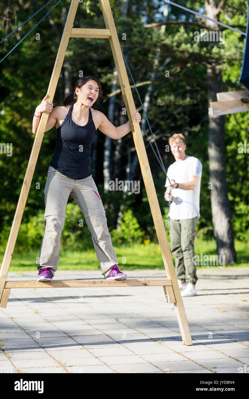 Femme criant sur la structure tout en tirant sur des cordes ami Patio Banque D'Images