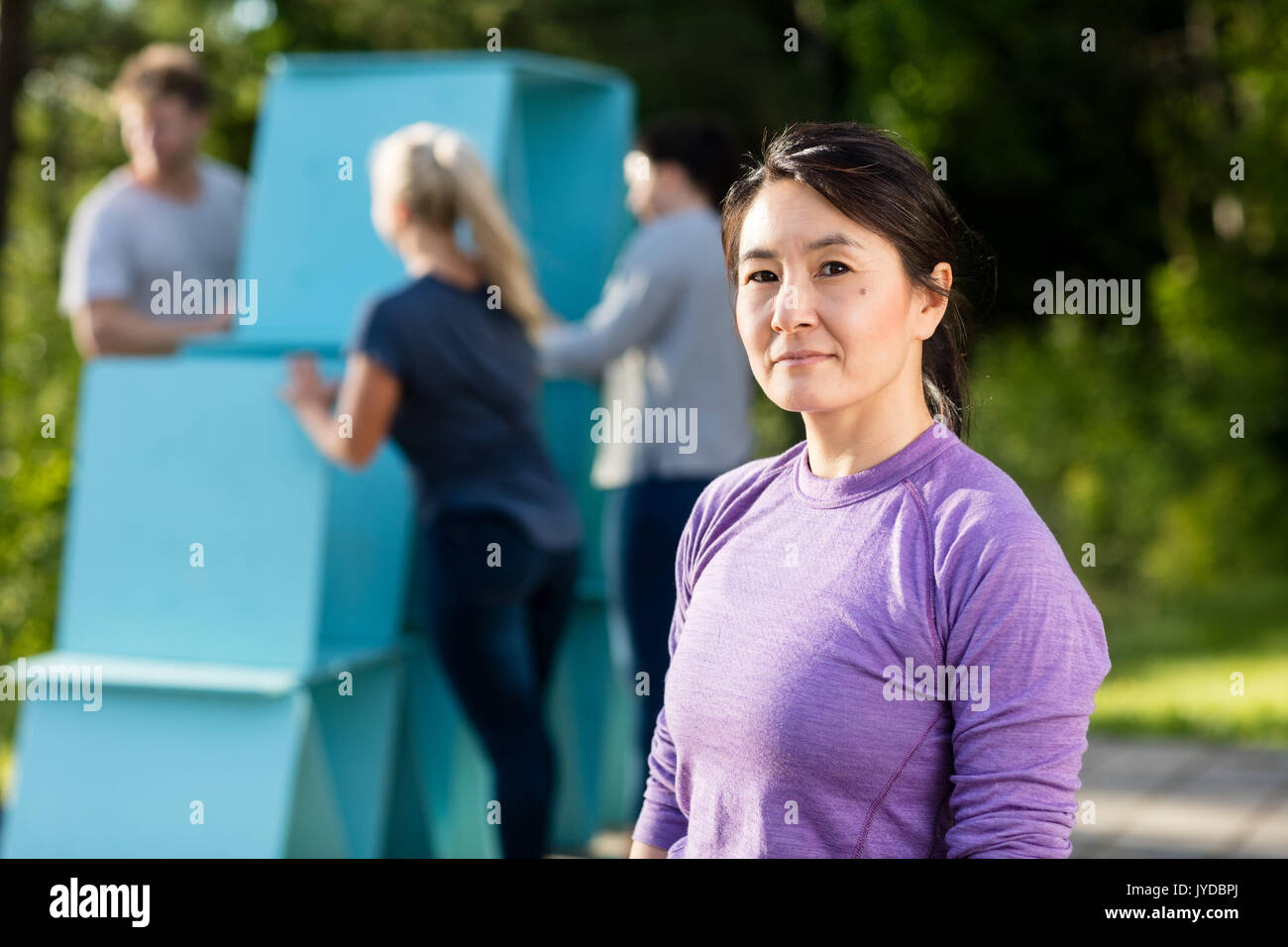 Mature Woman Standing tandis que les amis de faire pyramide de bandes Banque D'Images