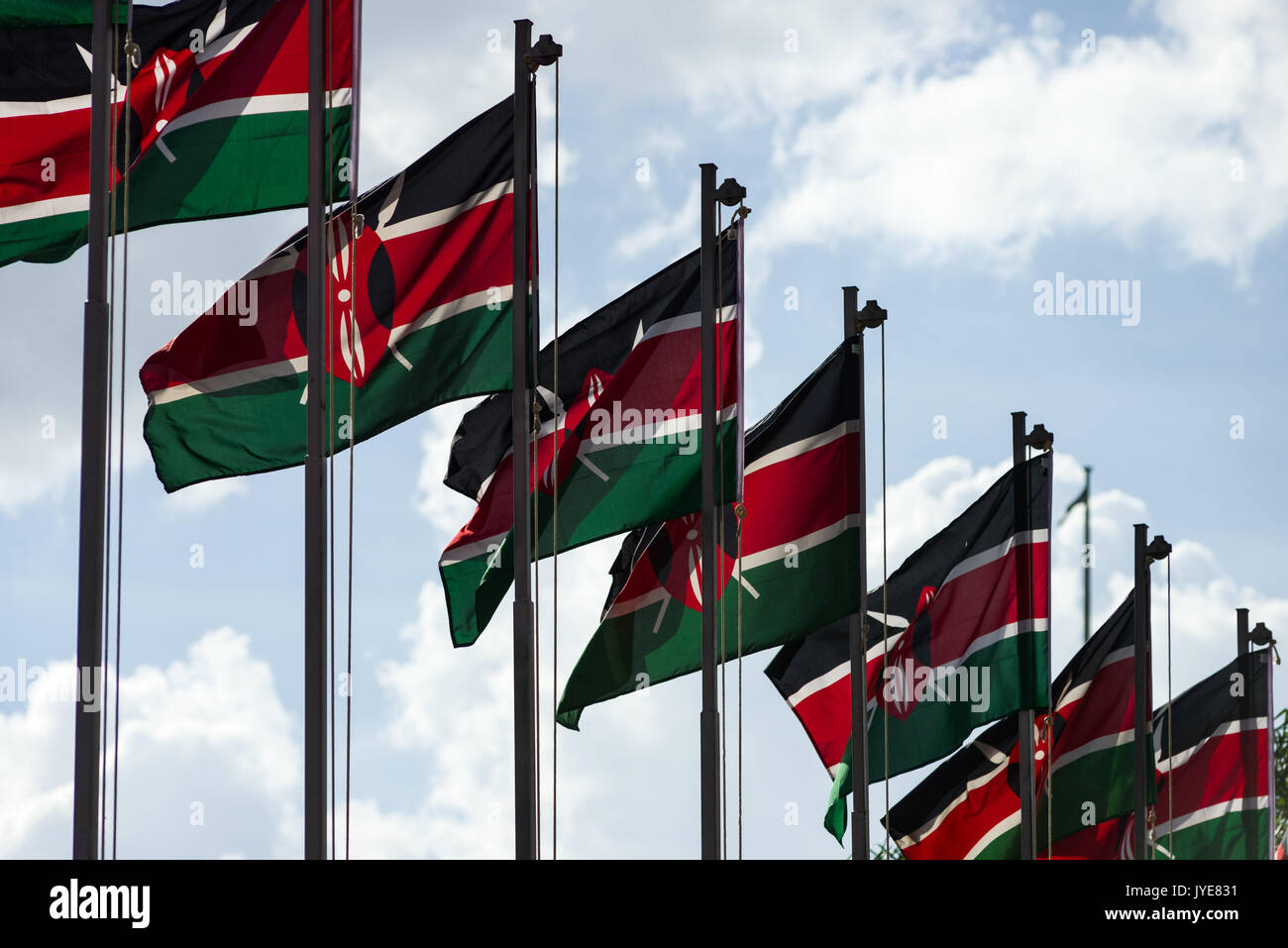 Une rangée de drapeaux du Kenya sur les poteaux dans le vent sur une journée ensoleillée, Nairobi, Kenya Banque D'Images