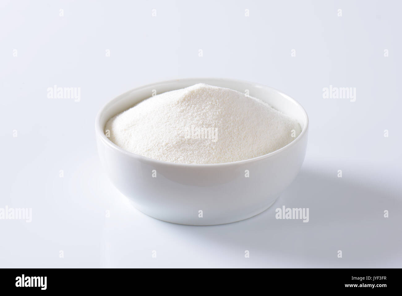 Bol de lait en poudre crème plein Banque D'Images