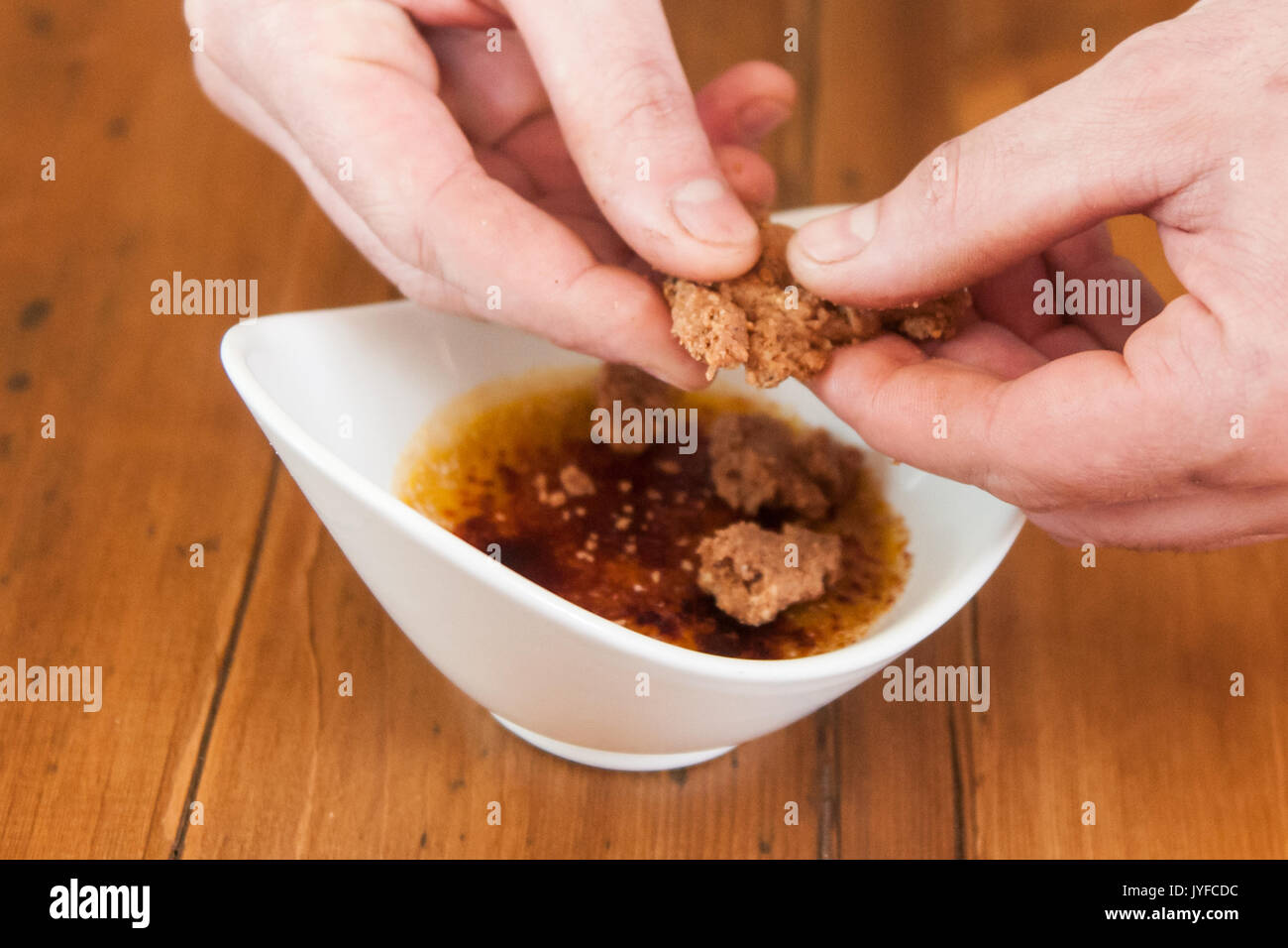 Un chef ajoute quelques biscuits pour une crème brûlée Banque D'Images
