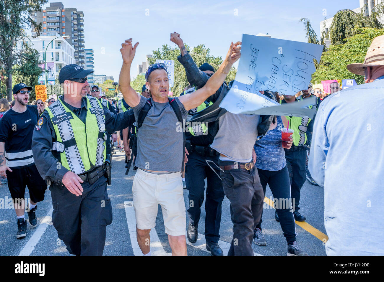 Vancouver, Canada. Août 19, 2017. L'homme a des réfugiés anti- poster arracha au grand rassemblement, à l'Hôtel de Ville, Vancouver, Colombie-Britannique, Canada. Crédit : Michael Wheatley/Alamy Live News Banque D'Images