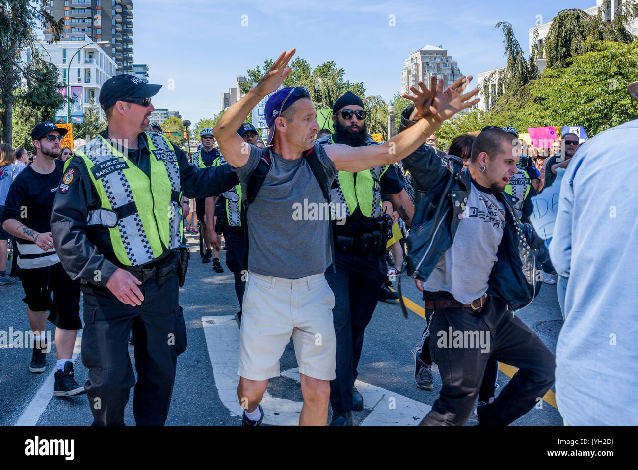 Vancouver, Canada. Août 19, 2017. L'homme a des réfugiés anti- poster arracha au grand rassemblement, à l'Hôtel de Ville, Vancouver, Colombie-Britannique, Canada. Crédit : Michael Wheatley/Alamy Live News Banque D'Images