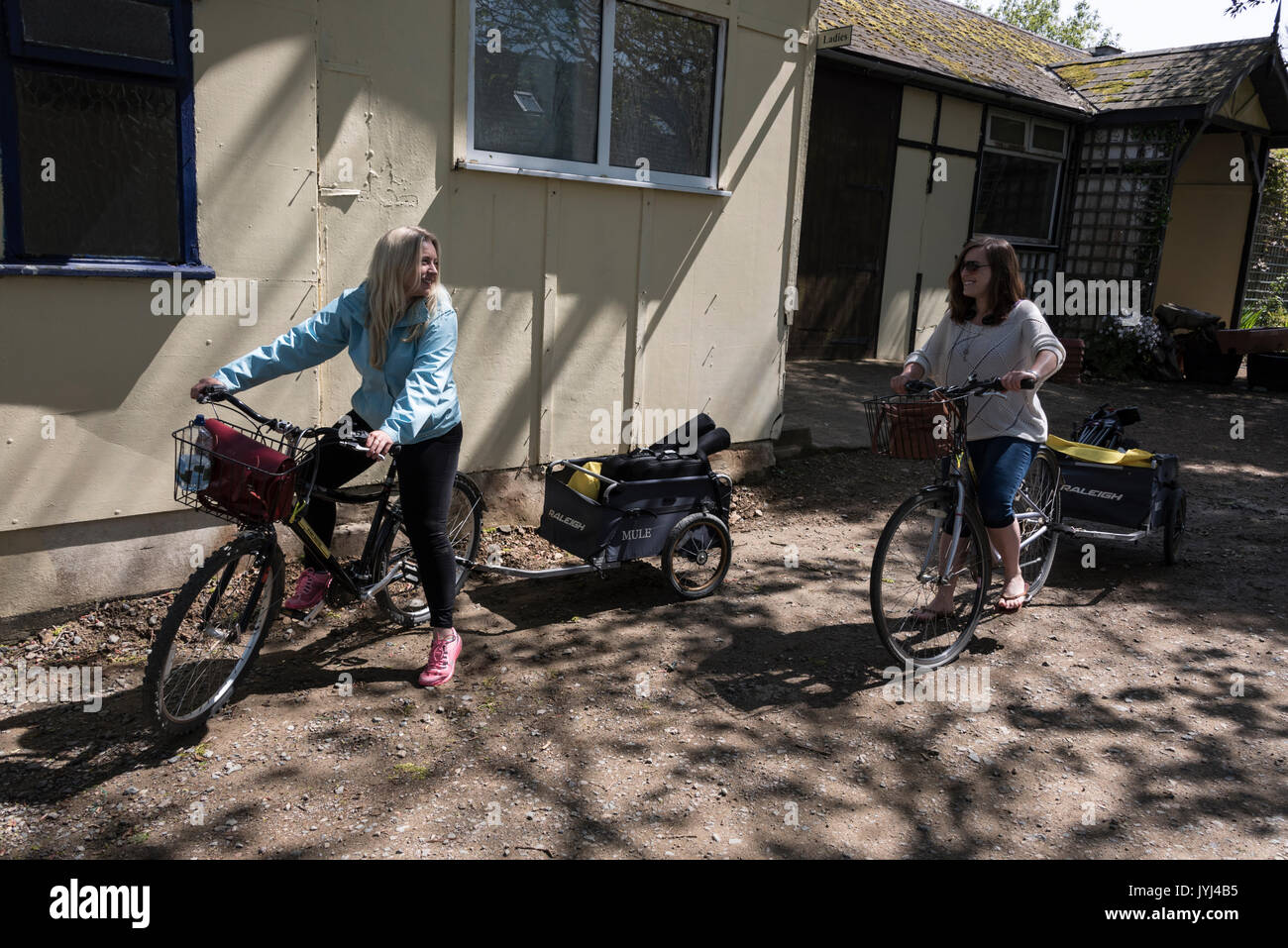 Un moyen facile d'obtenir environ est jeune journaliste de télévision et de l'appareil photo femme, transporter le cars de caméra et micro sur leur bicyclette dans l'île Banque D'Images