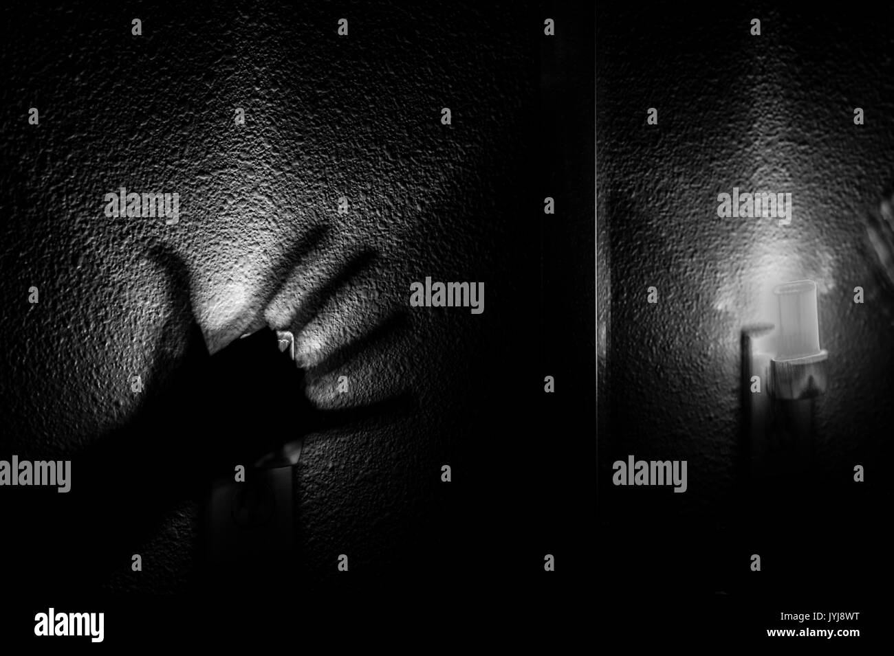 Veilleuse avec une main érie et troublée, image en noir et blanc Banque D'Images