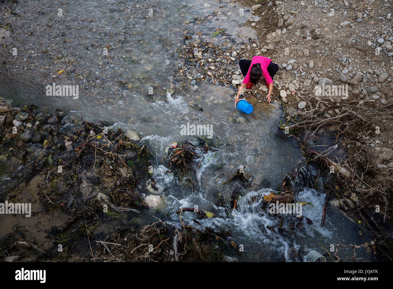 L'eau potable collecte d'une rivière à Beshkent, au Kirghizistan. L'eau est vulnérable à la contamination de la corbeille et les bactéries qui causent l'hépatite et d'autres maladies transmises par l'eau. Dans les villages à travers le Kirghizistan (Asie centrale) les systèmes de distribution d'eau vétustes et de l'infrastructure est la cause de problèmes de santé tels que des éclosions d'hépatite et de maladies gastro-intestinales, en particulier chez les enfants. Banque D'Images