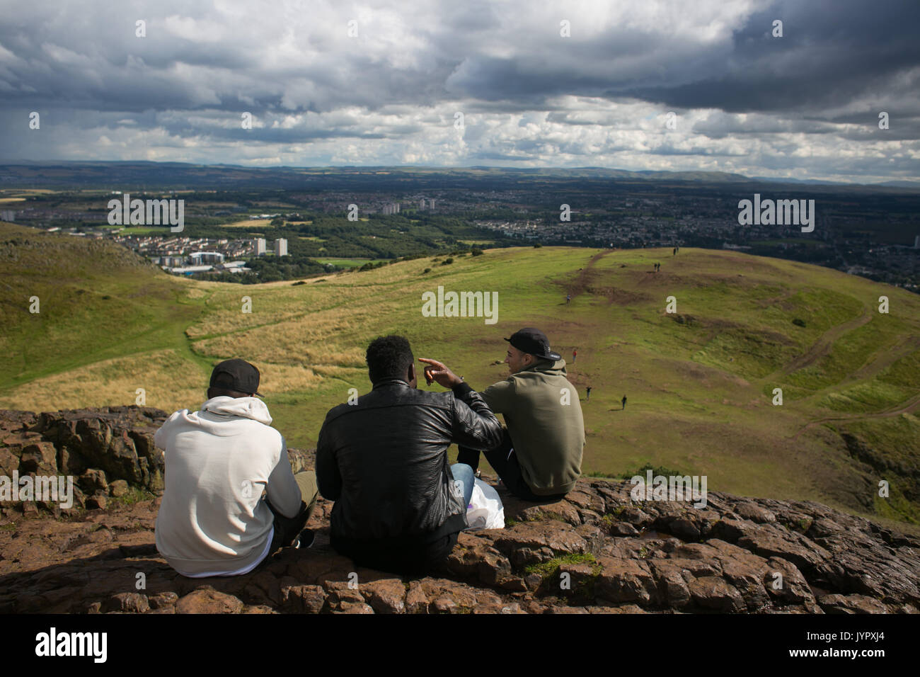 Trois amis se détendre sur la bière sur le haut de la crête. Le pic de King Arthur's Seat est une destination populaire pour les habitants et les touristes. La Crête et al. Banque D'Images