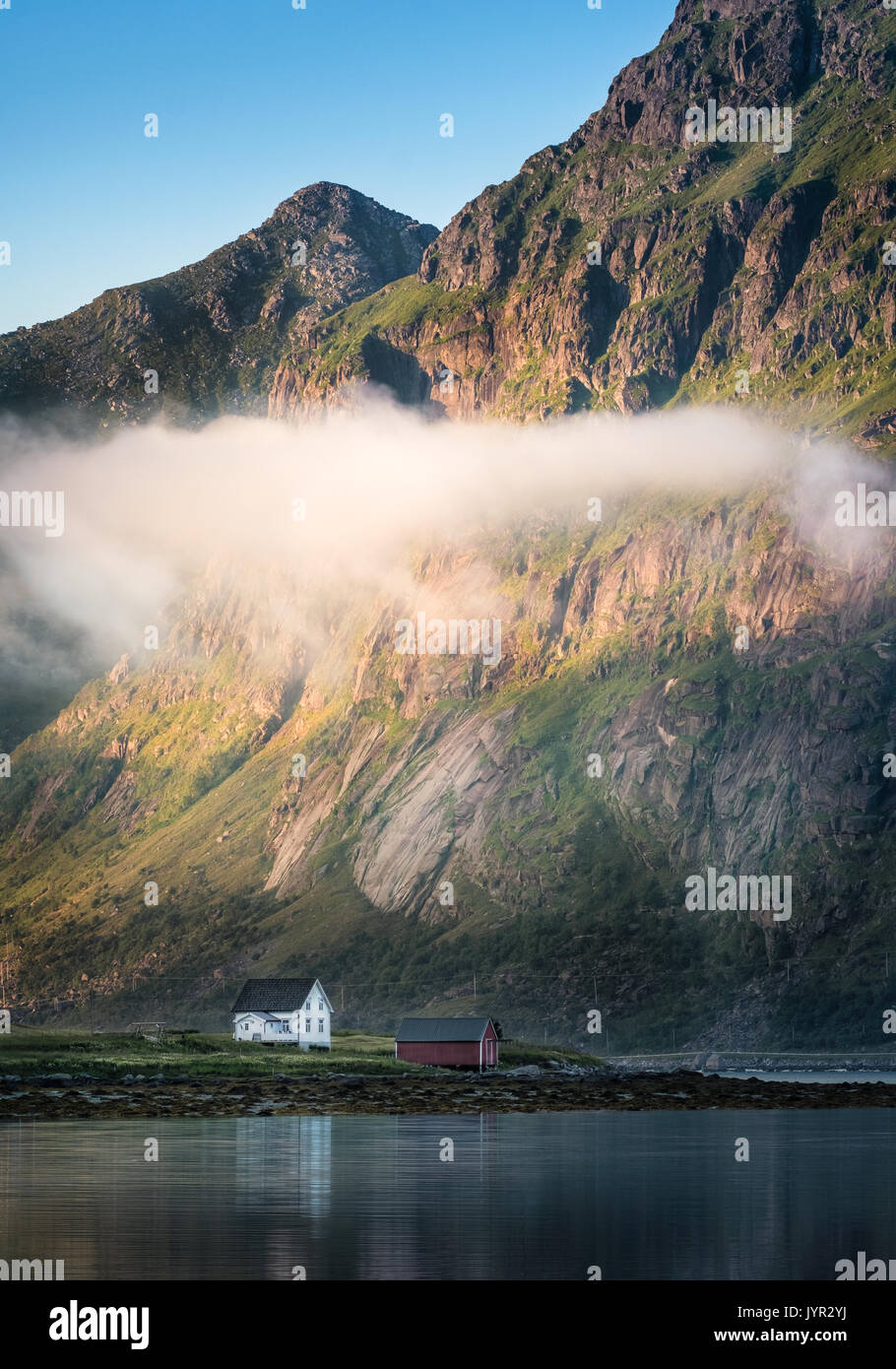 Vue panoramique avec maison idyllique et montagnes à soirée d'été dans les îles Lofoten, Norvège Banque D'Images Vue panoramique avec maison idyllique et montagnes à soirée d'été dans les îles Lofoten, Norvège Banque D'Images