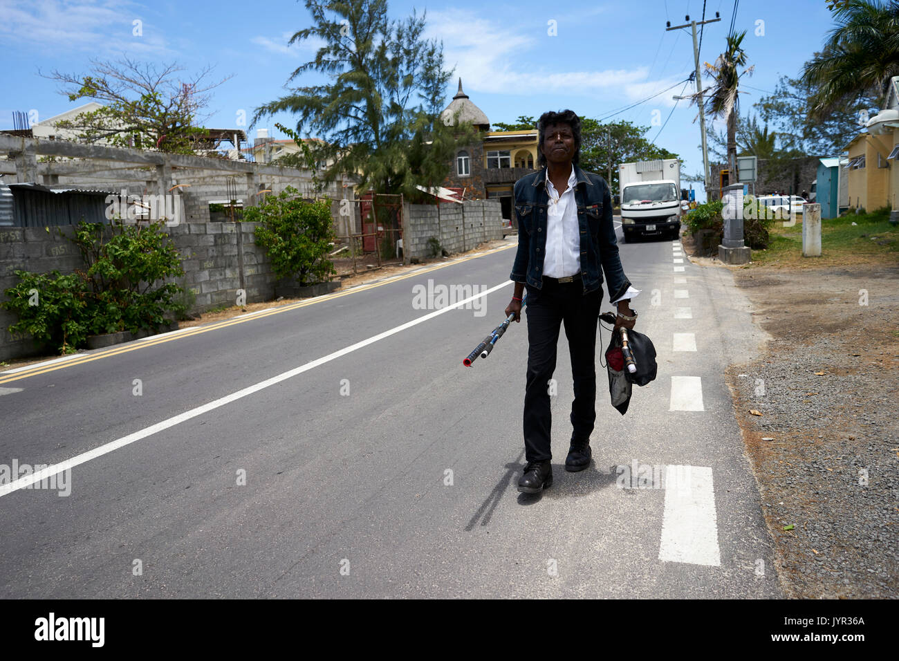 L'homme avec la canne à pêche va en bas de la route Banque D'Images