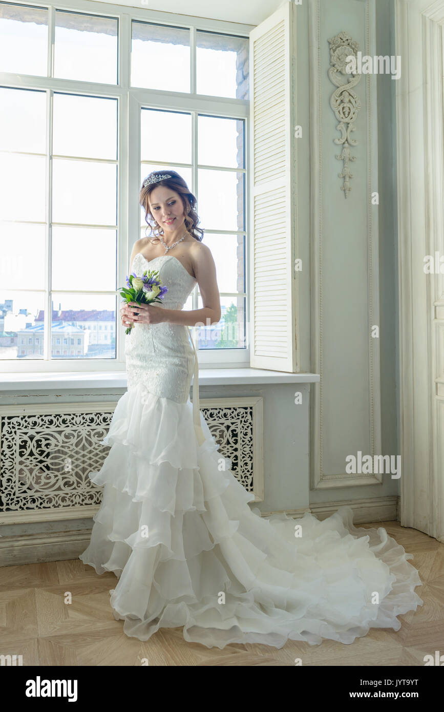 Young attractive madame en robe de mariage en studio Banque D'Images