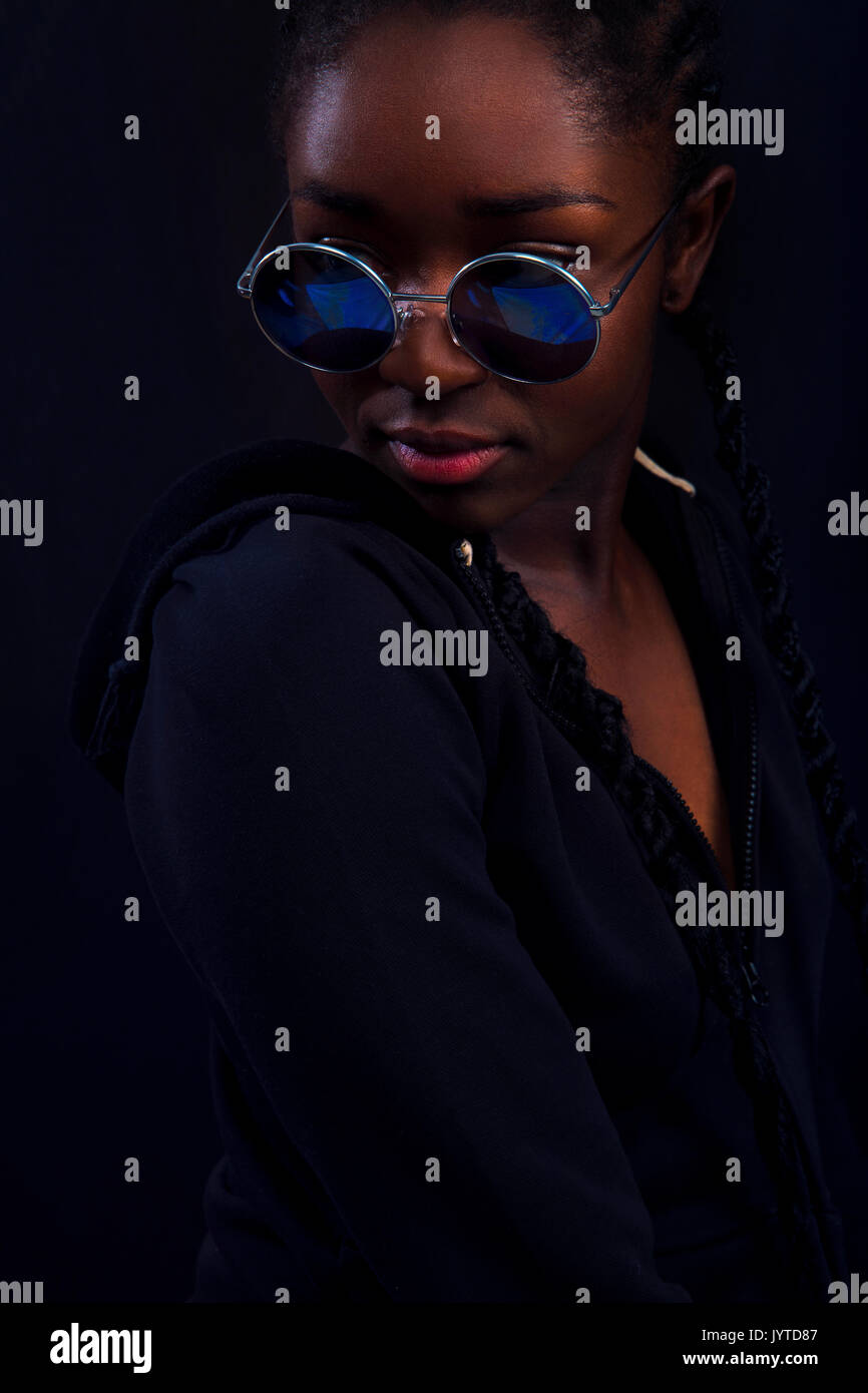 Cool jeune femme avec la peau foncée portant des lunettes rondes Banque D'Images