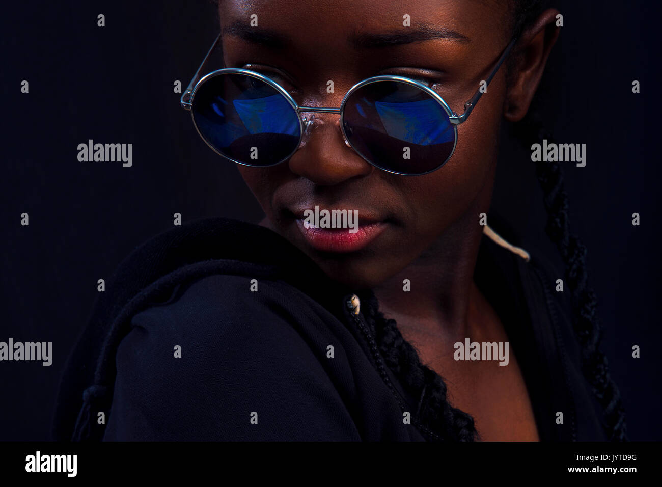 Portrait de femme avec la peau brune portant des lunettes rondes Banque D'Images