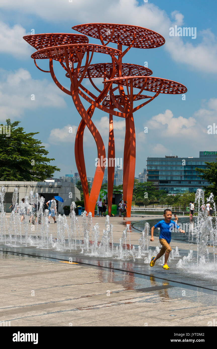 Garçon chinois sprint dans l'eau des fontaines à oct bay à Shenzhen, province de Guangdong, Chine Banque D'Images