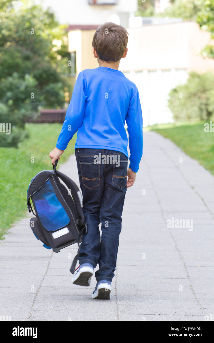 Joyeux petit garçon avec sac à dos ou sacoche appelé Ranzen en allemand. Un  écolier en