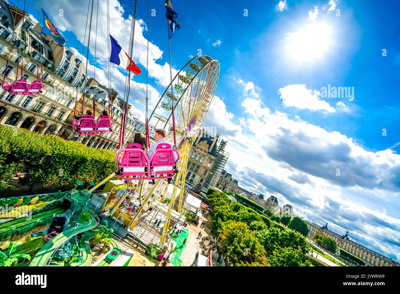 Les couples navigue dans les airs au-dessus des jardins des Tuileries lors du tour des chaises Swinging. Banque D'Images