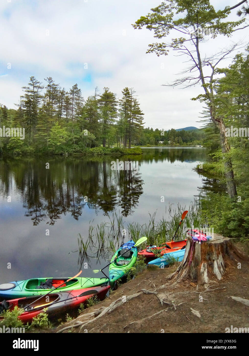 Un siège vide sport récréatif kayaks attachés le long de la côte à Bryant Pond dans le Maine, USA. Banque D'Images