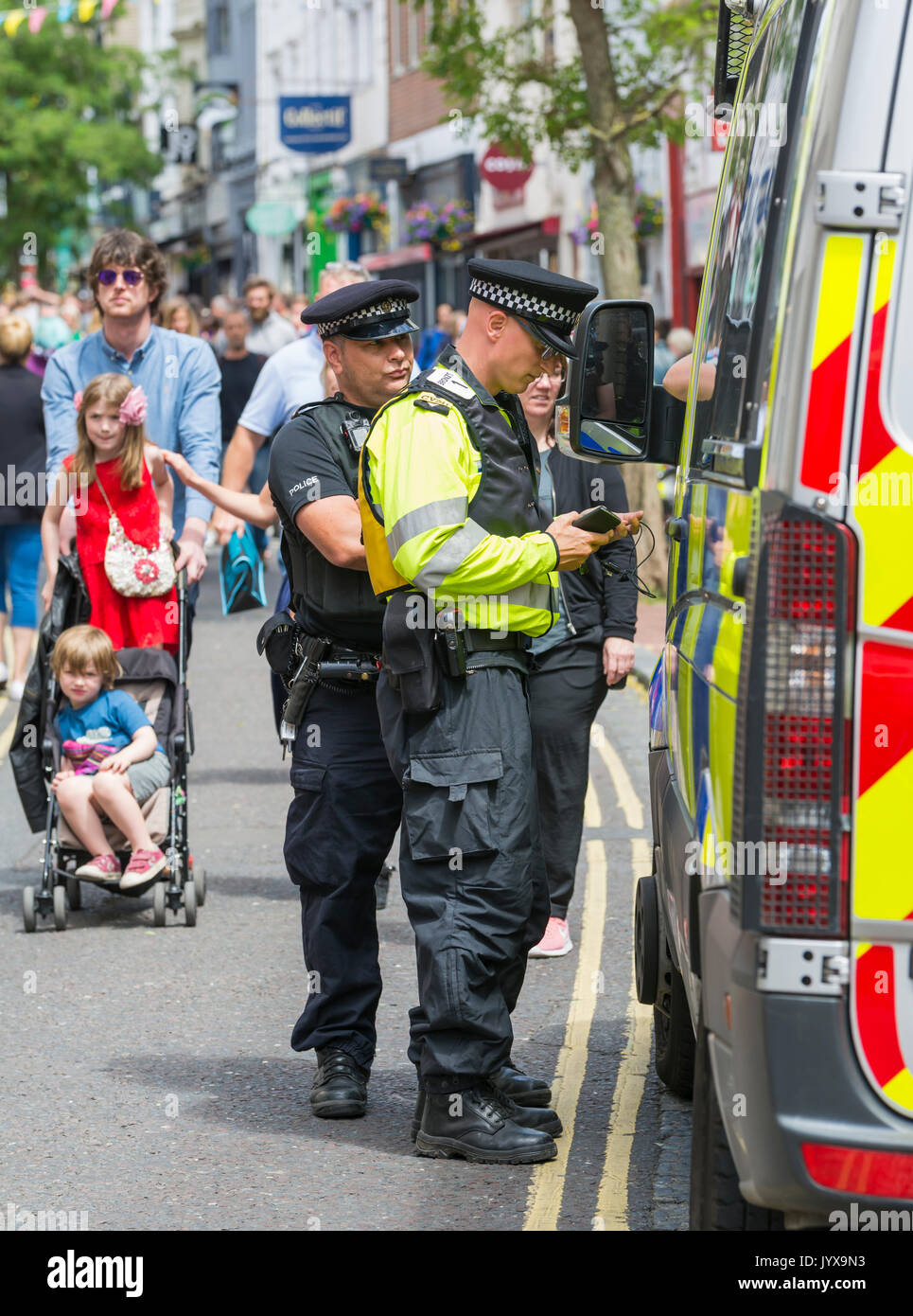 Des agents de police de police de Sussex debout à un fourgon de police dans la ville animée de Brighton, East Sussex, Angleterre, Royaume-Uni. Banque D'Images
