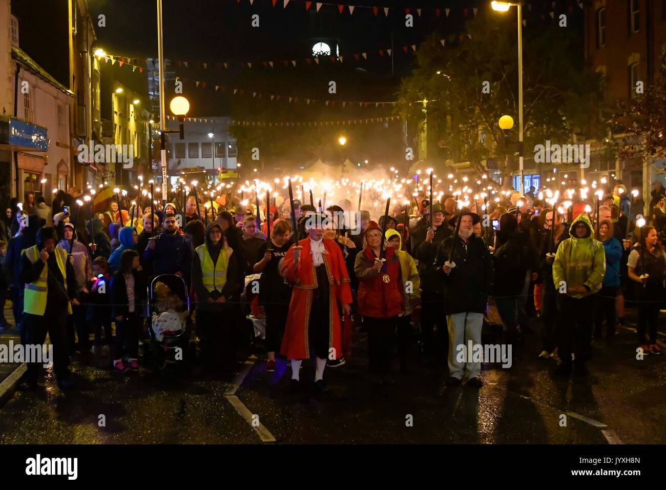 Bridport, Dorset, UK. 20 août 2017. Des centaines de personnes dirigée par le crieur public John Collingwood, maire Cllr Anne Rickard et la Rcbd David Rickard marche de Bridport Mairie pour la plage de West Bay, dans l'Assemblée Bridport Carnival Procession aux flambeaux. L'événement a été stiil un tirage d'un grand nombre de personnes malgré les fortes pluies au cours de la soirée dans la construction jusqu'à elle. Crédit photo : Graham Hunt/Alamy Live News Banque D'Images