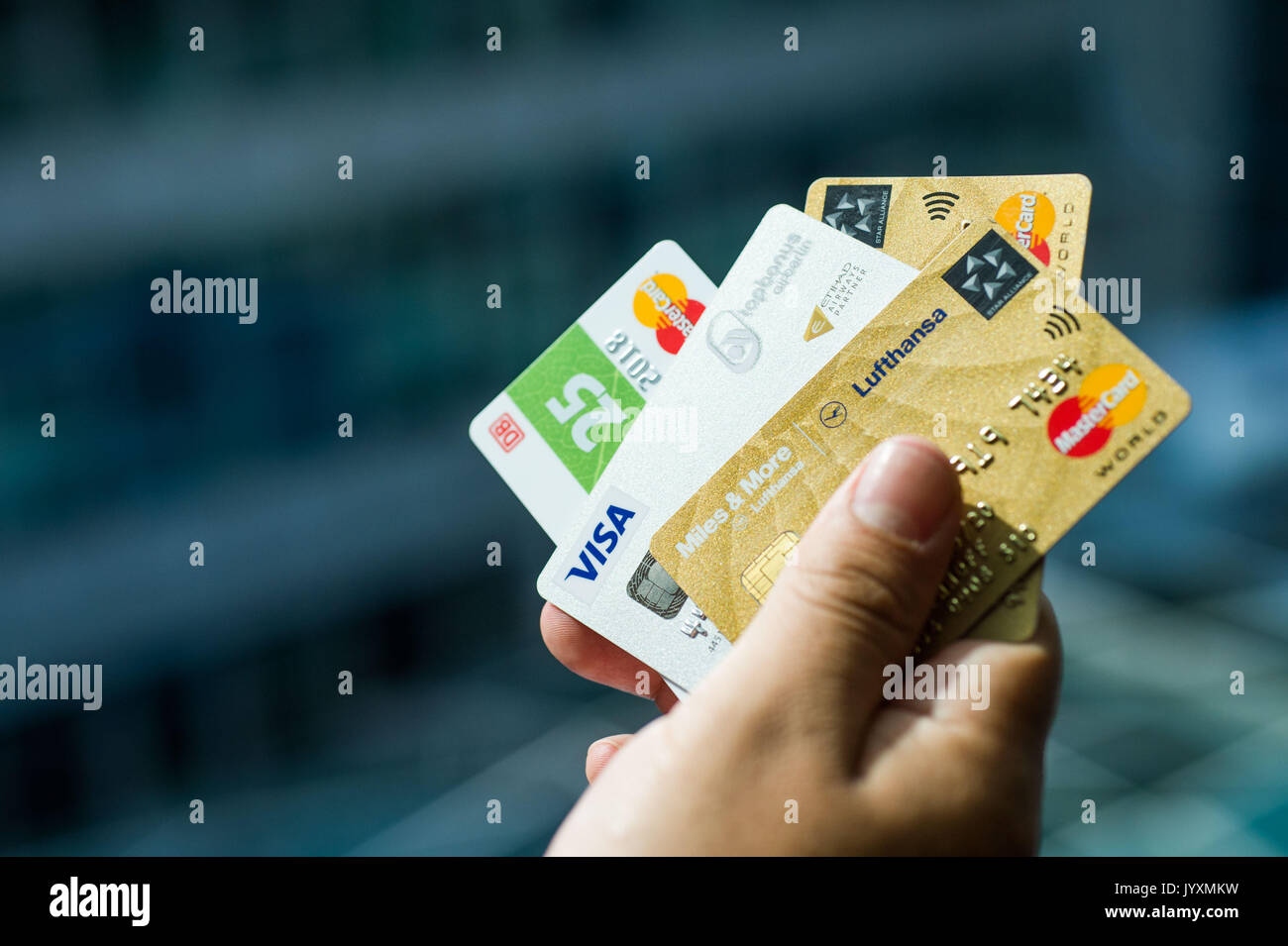 Berlin, Allemagne. 18 août, 2017. Cartes de crédit - Illustration par différentes entreprises privées détenues par une main à Berlin, Allemagne, 18 août 2017. De droite à gauche : Lufthansa, Air Berlin, Etihad Airways et Deutsche Bahan (chemins de fer allemands). De plus en plus d'entreprises à attirer des clients avec leurs propres cartes de crédit. Ils promettent des avantages supplémentaires aux utilisateurs de réductions à la station pour un crédit moins cher. Cependant, les organismes de protection des consommateurs conseiller un examen détaillé des conditions d'utilisation avant de signer un contrat. Photo : Lino Mirgeler/dpa/Alamy Live News Banque D'Images