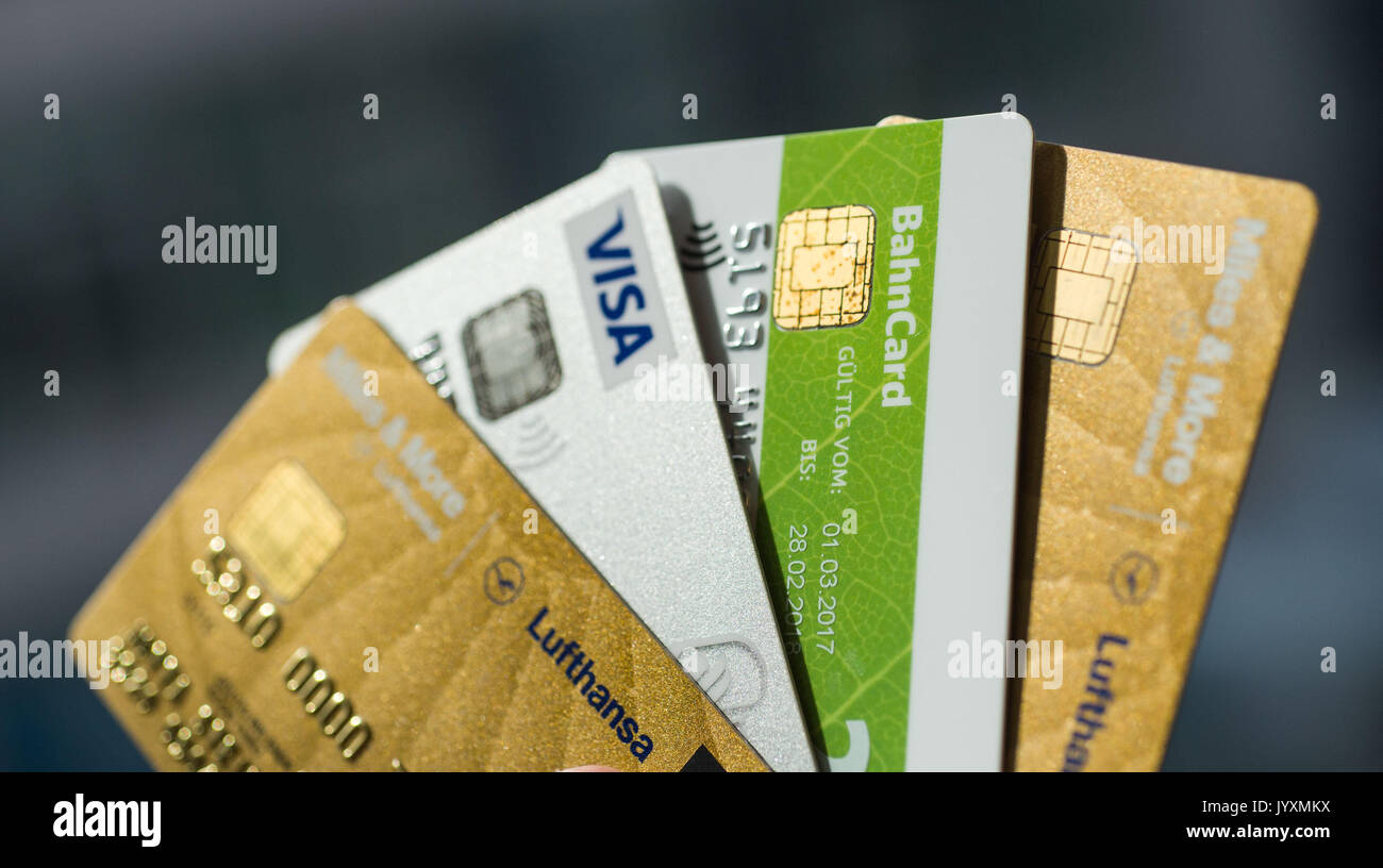 Berlin, Allemagne. 18 août, 2017. Cartes de crédit - Illustration par différentes entreprises privées détenues par une main à Berlin, Allemagne, 18 août 2017. De droite à gauche : Lufthansa, Air Berlin, Etihad Airways et Deutsche Bahan (chemins de fer allemands). De plus en plus d'entreprises à attirer des clients avec leurs propres cartes de crédit. Ils promettent des avantages supplémentaires aux utilisateurs de réductions à la station pour un crédit moins cher. Cependant, les organismes de protection des consommateurs conseiller un examen détaillé des conditions d'utilisation avant de signer un contrat. Photo : Lino Mirgeler/dpa/Alamy Live News Banque D'Images