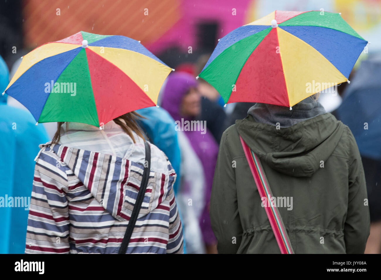 Festivaliers tentative de rester au sec pendant le V Festival à Weston Park à Littlehampton, Staffordshire. Banque D'Images