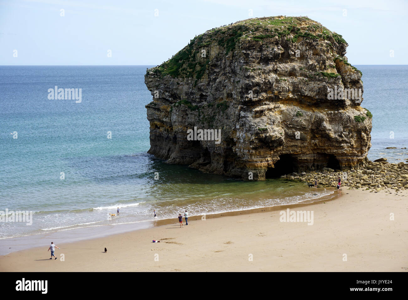 Les gens sur la plage de Marsden Rock une formation rocheuse de calcaire au large de la côte de la mer du Nord à South Shields en Angleterre Banque D'Images