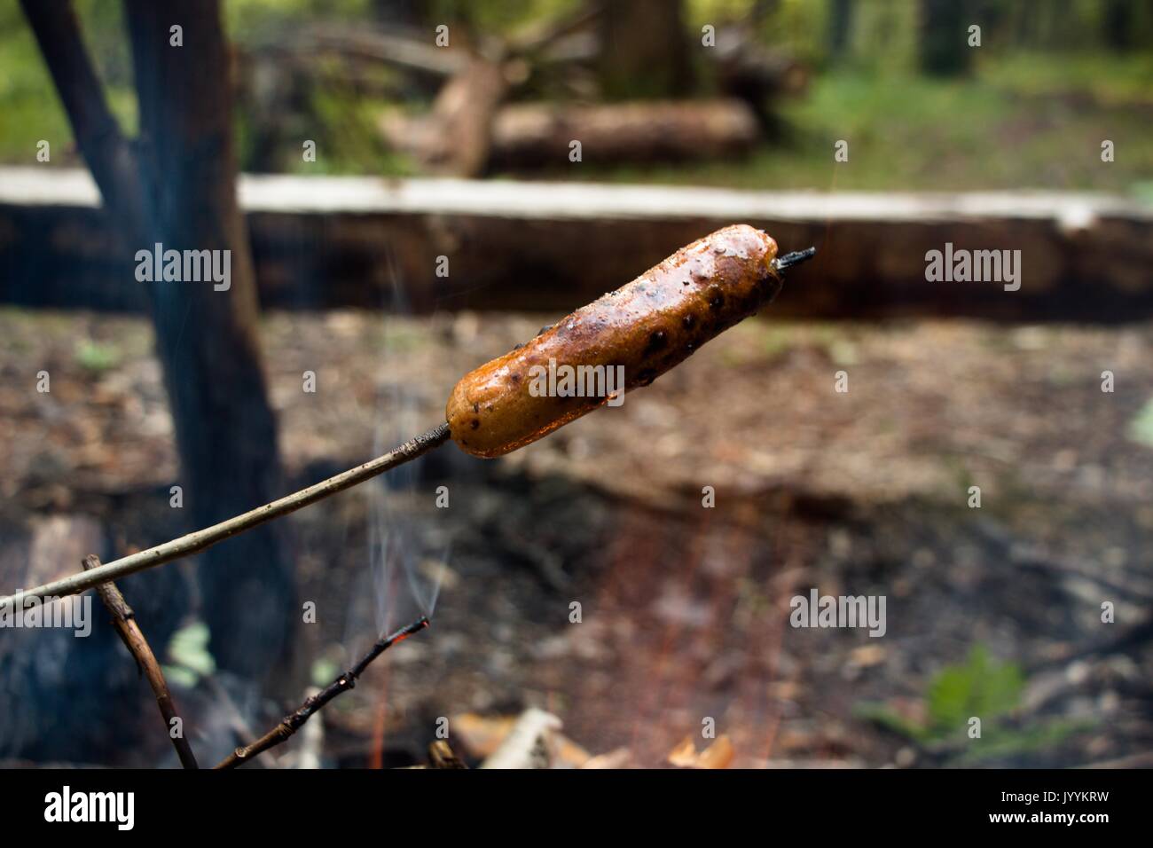 La saucisse est frit sur un feu ouvert avec une croix rouge et sauce épicée et est prêt à l'emploi. Préparé au cours d'une randonnée. Banque D'Images