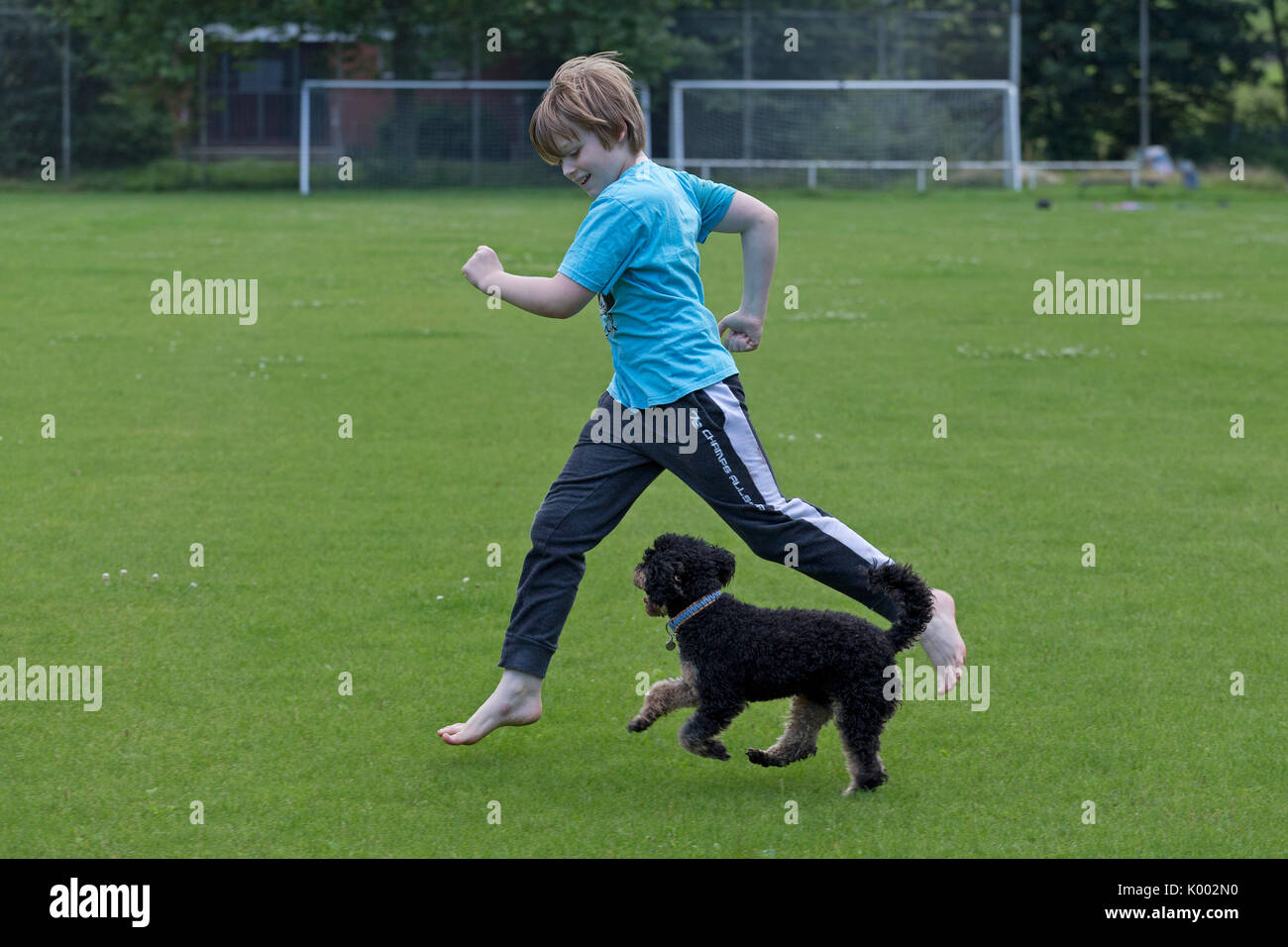 Jeune garçon courir avec chien Banque D'Images
