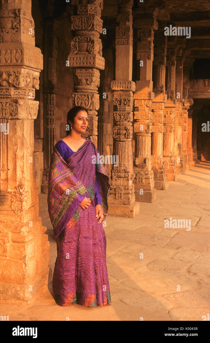 Femme en sari au milieu des piliers de grès sculpté complexe Qutb Minar, Delhi, Inde Banque D'Images