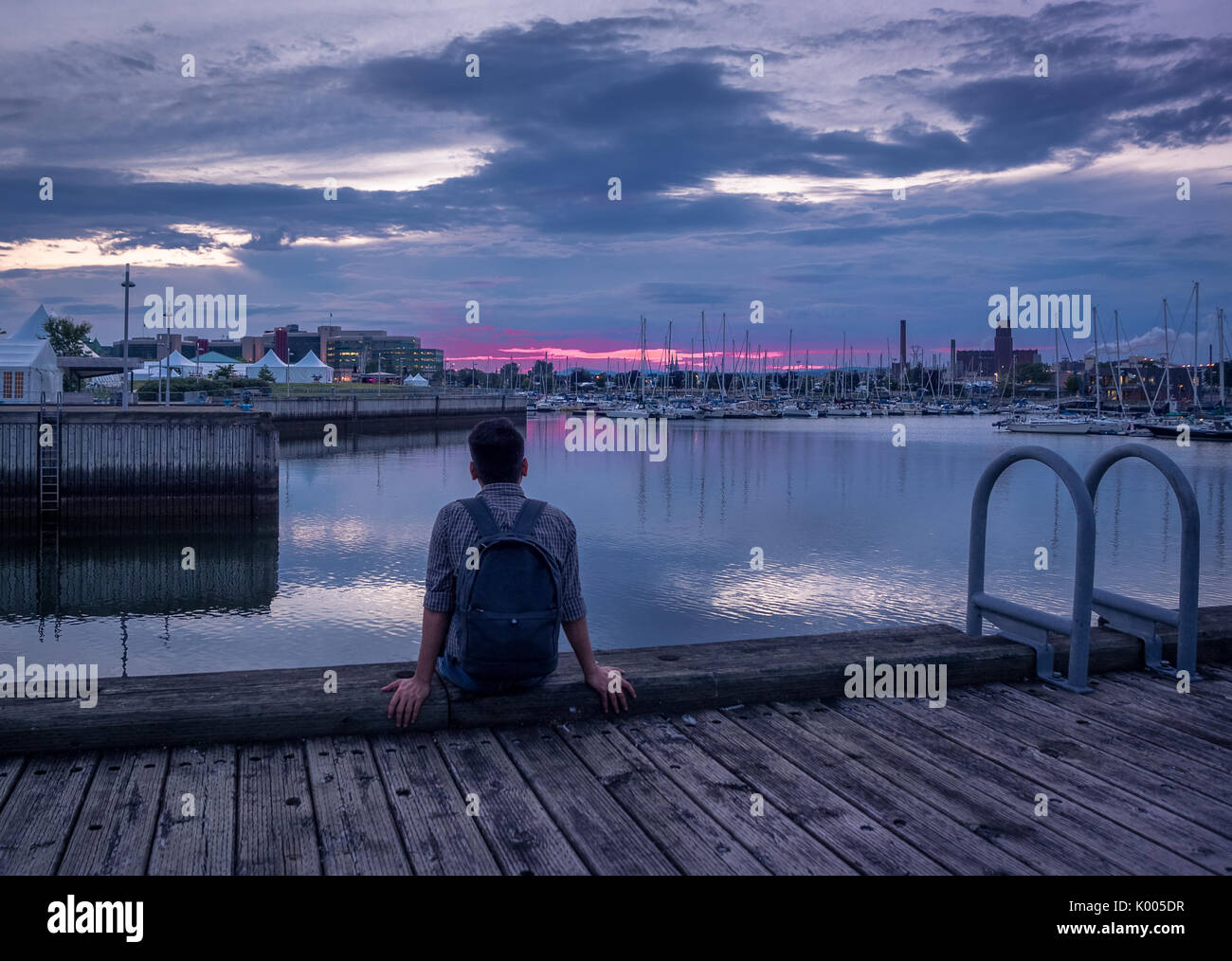 Un jeune homme d'admirer la dernière lumière du coucher du soleil à Québec, Canada par Quai Saint-andré Banque D'Images