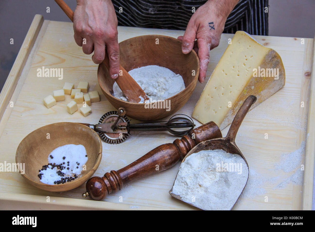 La main du Chef à remuer le mélange pour Sciatt un plat typique de la Valtellina. La Lombardie. L'Italie. L'Europe Banque D'Images