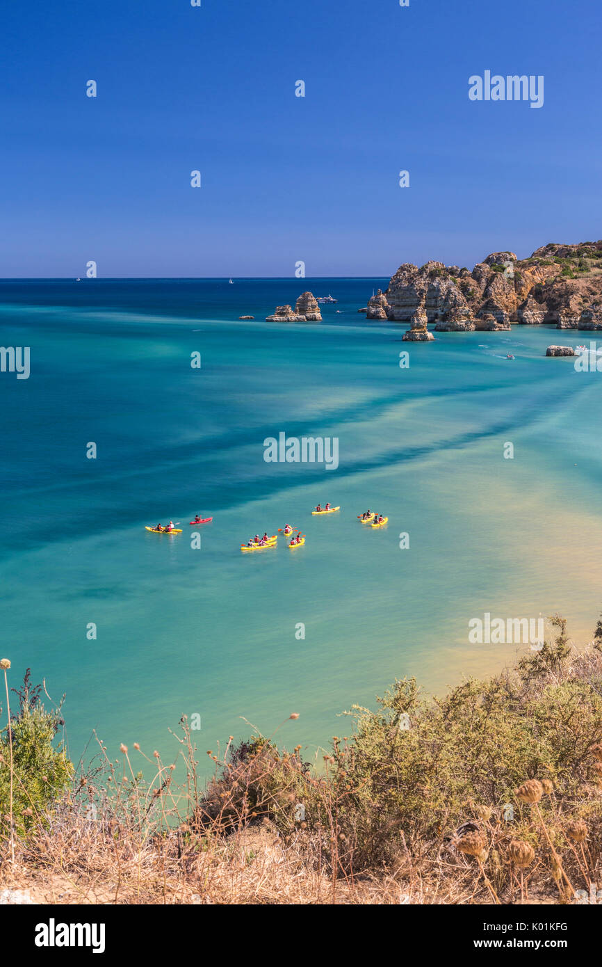 Canots dans l'eau turquoise de l'océan Atlantique qui entourent la plage Praia Dona Ana Lagos Algarve Portugal Europe Banque D'Images