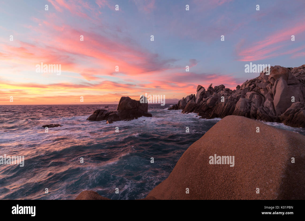 Ciel rose au coucher du soleil sur les vagues se briser sur les falaises Capo Testa Santa Teresa di Gallura Province de Sassari Sardaigne Italie Europe Banque D'Images