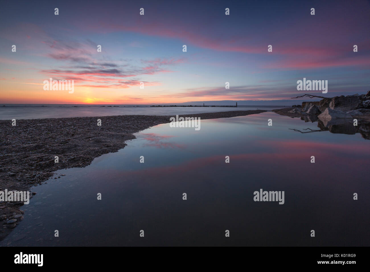 Pink sky se reflète dans l'eau claire à l'aube Porto Recanati province de Macerata Riviera del Conero Marches Italie Europe Banque D'Images