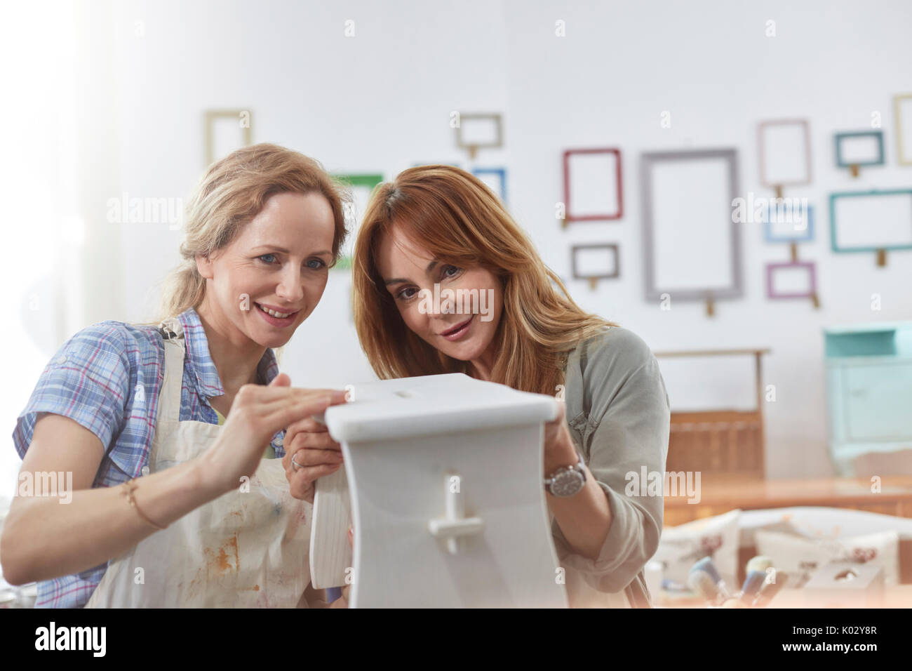 Les femmes artistes peinture banc en bois dans la classe d'art atelier Banque D'Images