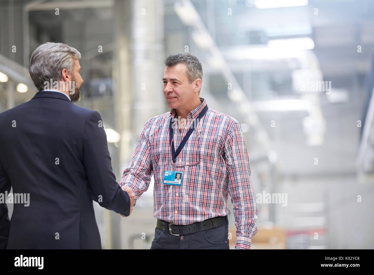 Businessman et superviseur handshaking in factory Banque D'Images
