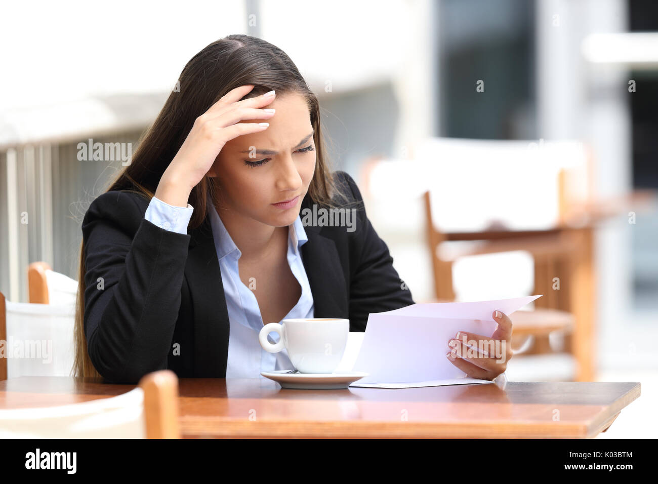 Inquiets de la lecture d'une lettre assis dans un café Banque D'Images