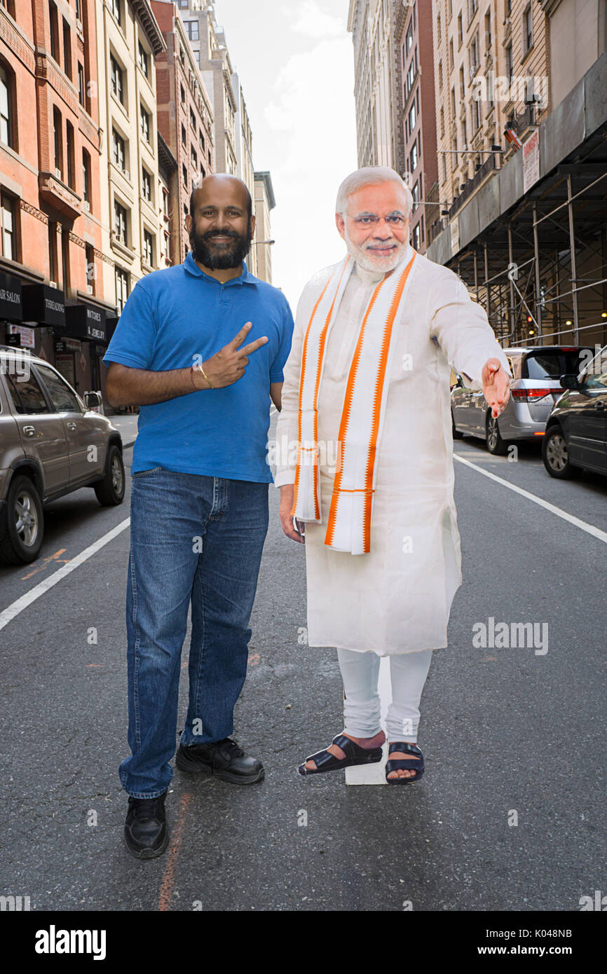 Un Indien américain) avec une taille de découpe de la vie du premier ministre de l'Inde Narendra Modi pose au début de l'Inde Day Parade à New York City Banque D'Images