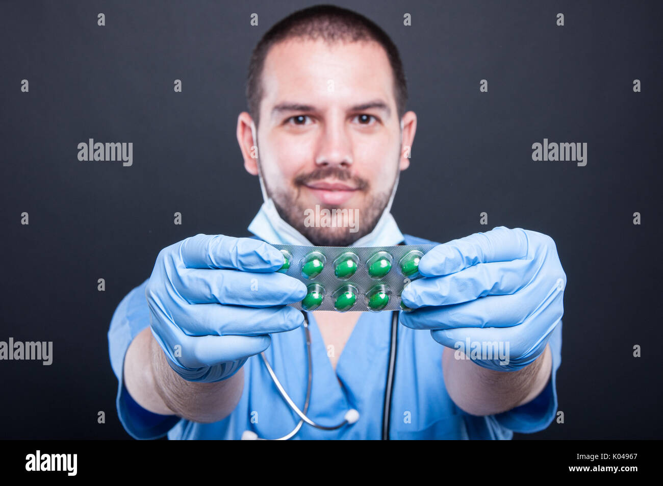 De mise au point sélective des gommages corporels holding tablets blisters et souriant sur fond noir Banque D'Images