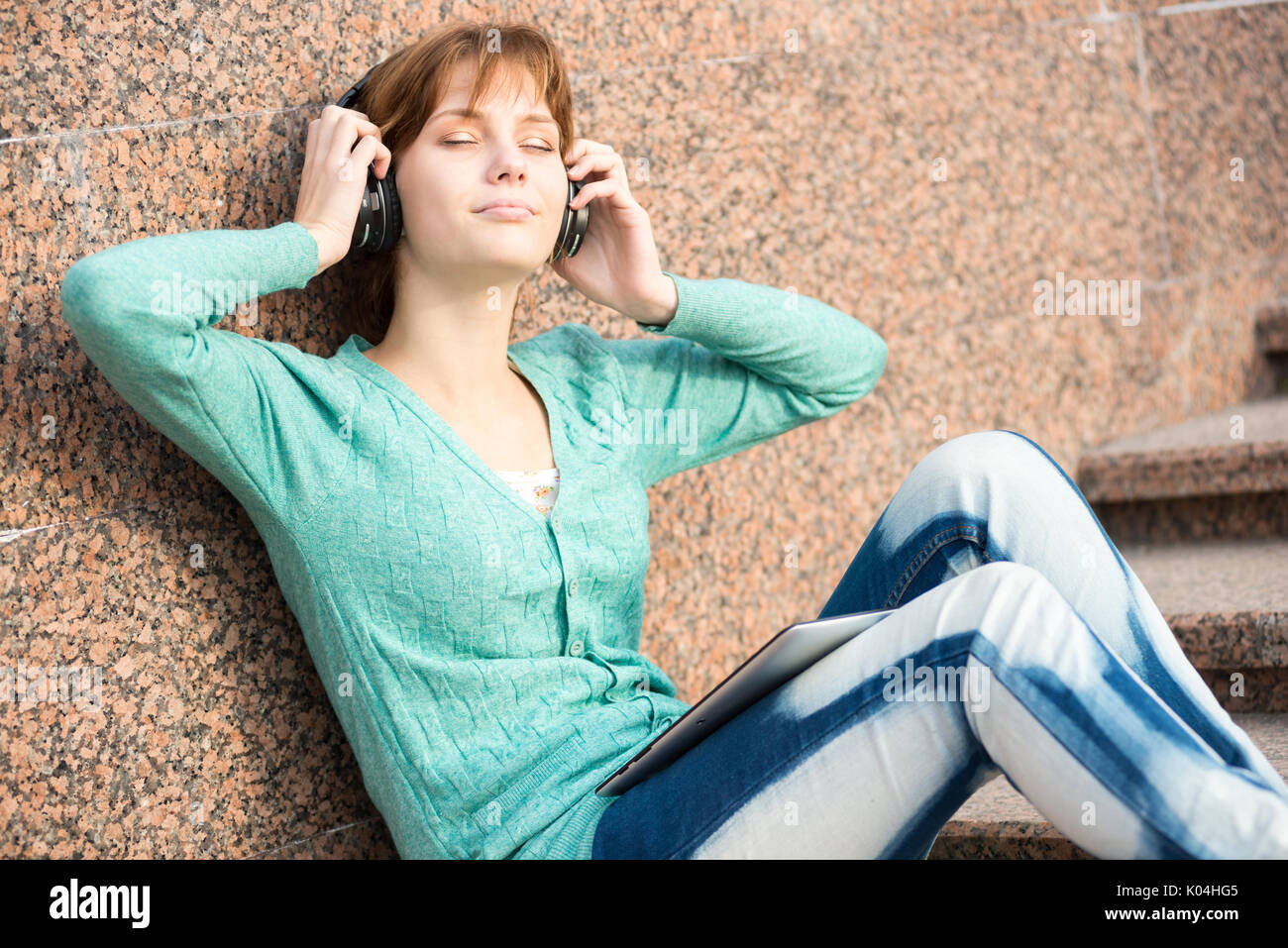 Belle jeune femme étudiant avec des écouteurs. Fille de musique en plein air Banque D'Images