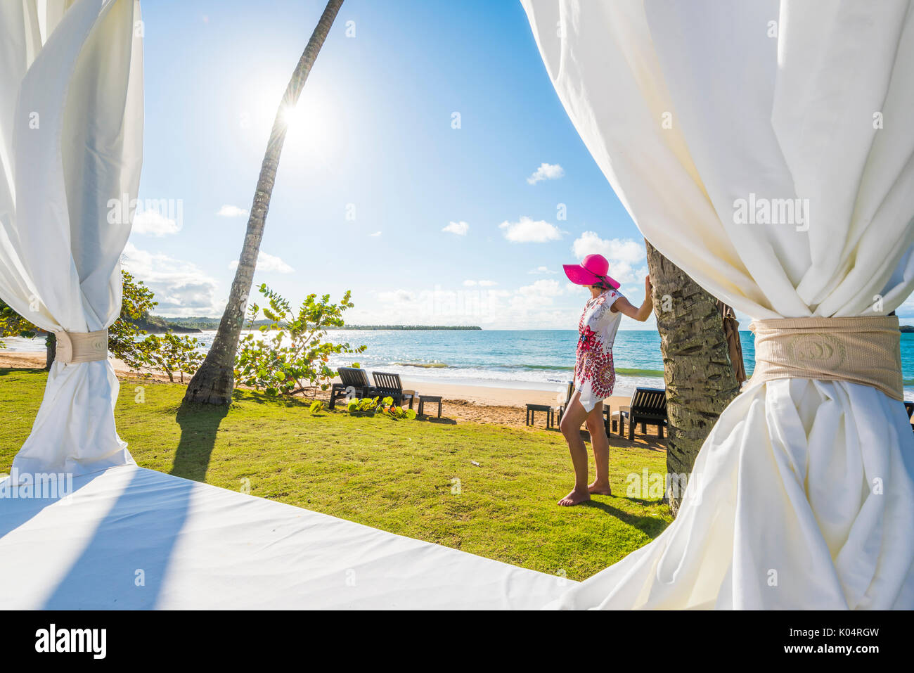 Playa Moron, Las Terrenas, Péninsule de Samana, République dominicaine. Belle femme admirant la vue depuis par un lit de plage (MR). Banque D'Images